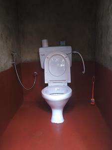 La salle de bains est pourvue de toilettes blanches. dans l'établissement MEPA HOMESTAY, à Cherrapunji