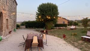un patio con mesa, sillas y luces en Arcadia Agriturismo, en San Nicola Manfredi