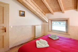 a bedroom with a red bed with a window at Appartamenti Lorenza 3 Baite Giotto in Livigno