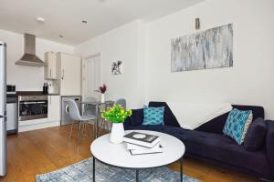 a living room with a blue couch and a table at Luxury Urban Living - 1 BDR in London
