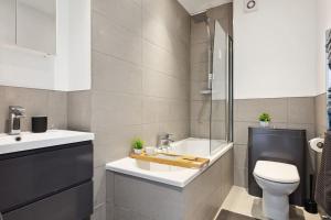 a bathroom with a toilet and a sink and a tub at Luxury Urban Living - 1 BDR in London