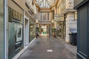 un callejón vacío en un edificio con tiendas en Rent a Room - 2P Passage du Caire, en París