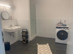 a bathroom with a sink and a washing machine at Boho Appartement in Bielefeld