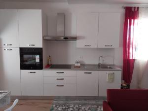 a kitchen with white cabinets and a sink and a microwave at La Casa sul lago in Fara San Martino