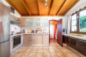 a kitchen with white cabinets and a wooden ceiling at Villa Loira in Corralejo