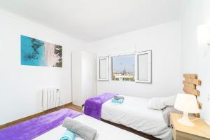 um quarto com 2 camas e um sofá em Townhouse Forteza By homevillas360 em Colonia de Sant Pere