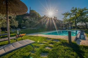 a swimming pool with a bench and an umbrella at La Folaga del Trasimeno in Magione