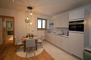 a kitchen and dining room with a table and chairs at Design Residence Nellere II in Padola