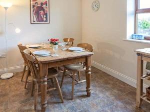 a dining room with a wooden table and chairs at Rose Cottage in Richmond