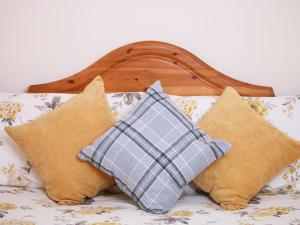 a bunch of pillows sitting on a bed at Rose Cottage in Richmond