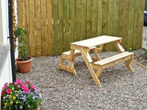 a picnic table and a bench next to a fence at Rose Cottage in Richmond