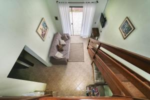 sala de estar con escalera y sofá en 2 quadras da Praia de Zimbros, 9 hóspedes RW2724, en Bombinhas