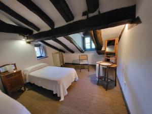 a bedroom with a white bed and two windows at Casa Rural El Amparuco in Treceño