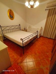 a bedroom with a bed and a red tile floor at Villa dei pioppi in Marconia