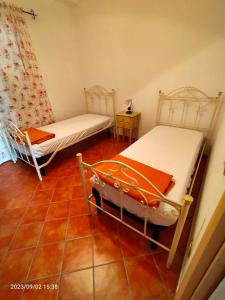 a room with two beds and a tiled floor at Villa dei pioppi in Marconia