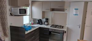 a small kitchen with a sink and a microwave at le lac des rêves in Lattes