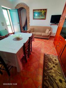 ein Wohnzimmer mit einem Tisch und einem Sofa in der Unterkunft Villa dei pioppi in Marconia