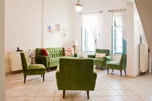 a living room with green chairs and a couch at Lilian's House in Chania Town