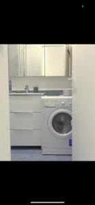 a kitchen with a washing machine and a sink at se: 13A rue des Touleuses Pourpre in Cergy