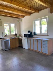 a large kitchen with wooden cabinets and appliances at Bajkowy Domek nad rzeką Liwiec in Łochów