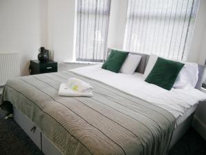 a bedroom with a large bed with towels on it at Rock Lane House by Serviced Living Liverpool in Rock Ferry