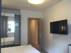 een slaapkamer met een bed en een flatscreen-tv aan de muur bij monas home mayrhofen in Mayrhofen