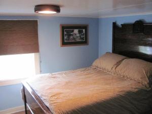 1 cama en un dormitorio con una pared azul en Wolf Cove Retreat House, en Amherst Cove