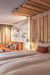 a bedroom with a large bed and a couch at BaseCamp Hotel in Zermatt