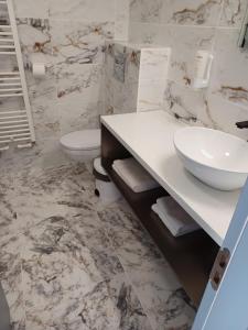 une salle de bain avec un lavabo et des toilettes dans l'établissement Motel Moara Veche, à Săcălăşeni