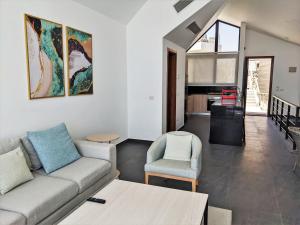 ein Wohnzimmer mit einem Sofa und 2 Stühlen in der Unterkunft Sea View 2BR Villa with Free Beach & Pool in Soma Bay in Hurghada