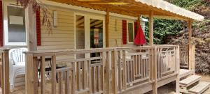 a front porch of a house with a wooden deck at le lac des rêves in Lattes