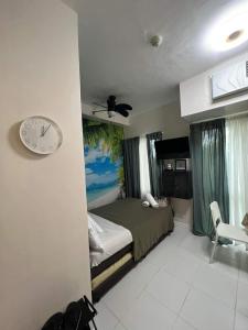 a bedroom with a bed and a clock on the wall at Casa Coco @ La bella, Tagaytay in Tagaytay