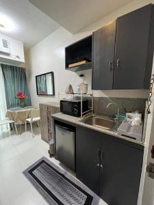 a kitchen with a sink and a microwave at Casa Coco @ La bella, Tagaytay in Tagaytay