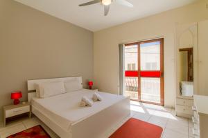 - une chambre blanche avec un grand lit blanc et une fenêtre dans l'établissement Well Located Townhouse & Courtyard Kalka - Happy Rentals, à Kalkara