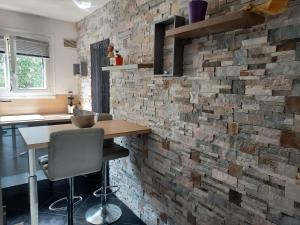 - un mur en briques dans une cuisine avec une table et des chaises dans l'établissement LES JARDINS D'ATILLY, à Villecresnes