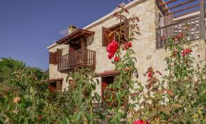 un edificio de piedra con balcón y rosas rojas en Phaedrus Living: Amarakos Villa en Pafos