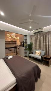 a bedroom with a large bed and a kitchen at Boho Studio in Pune