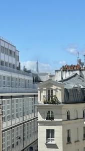 a large white building with a balcony on top of it at Le Mira - Paris centre - vue Tour Eiffel in Paris