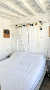 a white bed in a white room with balloons on the ceiling at Le Mira - Paris centre - vue Tour Eiffel in Paris