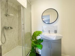 een badkamer met een douche, een wastafel en een spiegel bij Rock Lane House by Serviced Living Liverpool in Rock Ferry