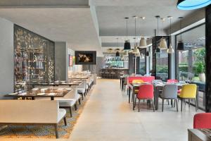 a restaurant with tables and chairs and a bar at Citadines Arpora Nagoa Goa in Arpora