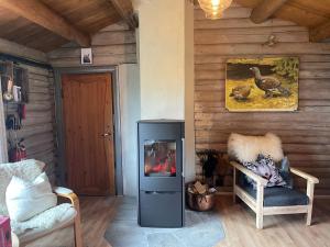 ein Wohnzimmer mit einem Kühlschrank und einem Stuhl in der Unterkunft Buhaug - cabin at Sjusjøen in Ringsaker
