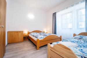 a bedroom with two beds and a desk and a window at Lesák rekreační středisko in Chlum u Třeboně