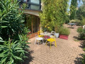 a patio with a table and chairs and plants at Le gîte des Tourterelles in Belleville-sur-Saône