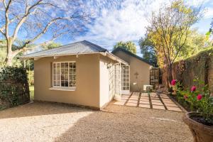 une petite maison blanche avec une clôture dans l'établissement Jeppe house cottage, à Pretoria