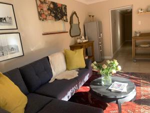 un soggiorno con divano e tavolo di Jeppe house cottage a Pretoria