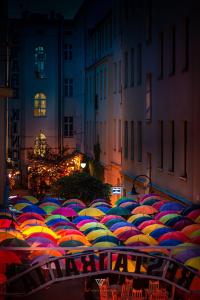 a bunch of colorful umbrellas sitting in the street at Stare Kino Cinema Residence in Łódź