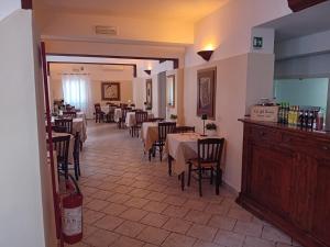 un comedor con mesas y sillas en un restaurante en Locanda Il Portone en San Colombano al Lambro