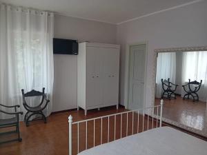 1 dormitorio con armario blanco y espejo en Locanda Il Portone en San Colombano al Lambro