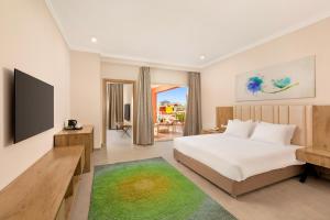 a bedroom with a bed and a television in a room at Neverland City Hurghada - Pickalbatros in Hurghada